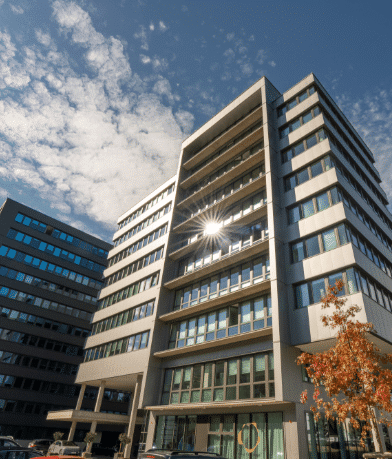 Moderne Bürogebäude mit Glasfassaden im Technopark Raaba bei sonnigem Himmel.
