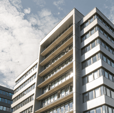 Modernes Wohngebäude vor blauem Himmel mit Wolken.